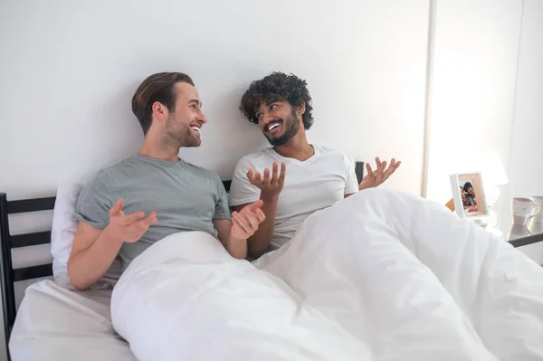 Homosexuella par pratar med varandra i sovrummet. — Stockfoto
