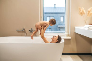 Neşeli kadın ebeveyn çocuğuyla oynuyor.