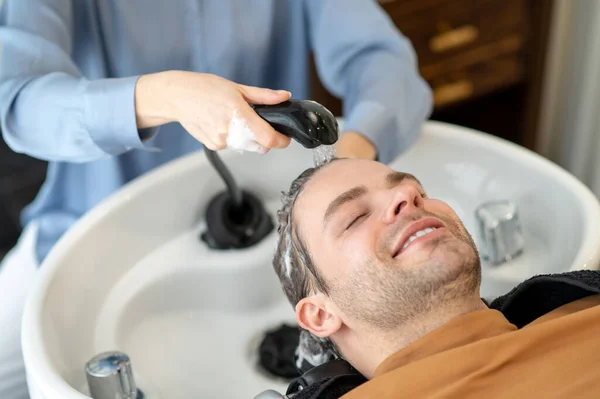 Fodrász mosás haj a férfi ügyfél egy szépségszalonban — Stock Fotó