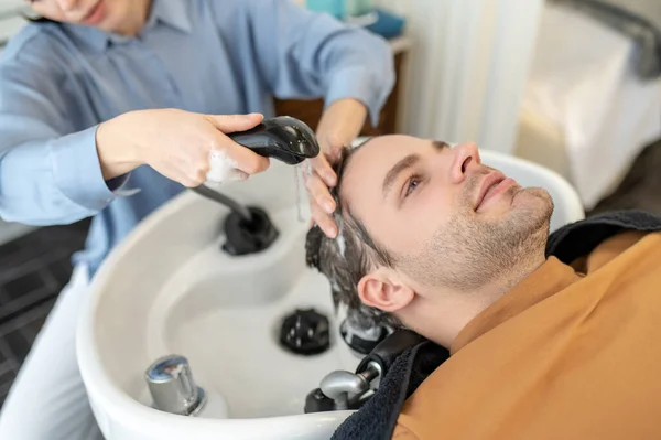 Peluquería lavar el cabello al cliente masculino en un salón de belleza — Foto de Stock