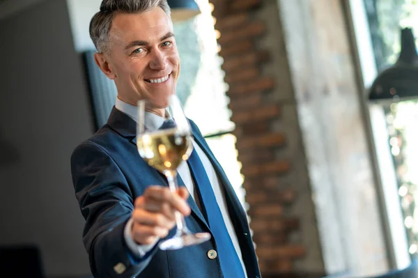 Glimlachende man met een glas wijn in handen — Stockfoto