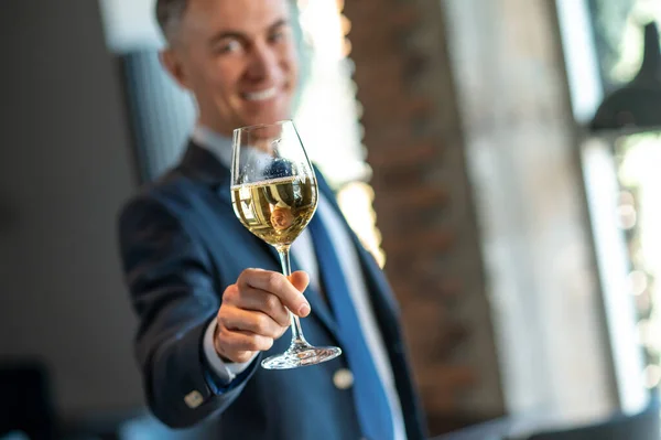 Hombre sonriente con una copa de vino en las manos — Foto de Stock