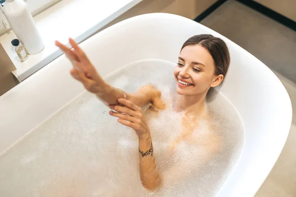 Freudige Dame wäscht sich in der Badewanne — Stockfoto