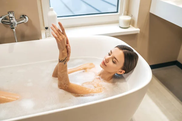Спокойная женщина моется в ванной — стоковое фото