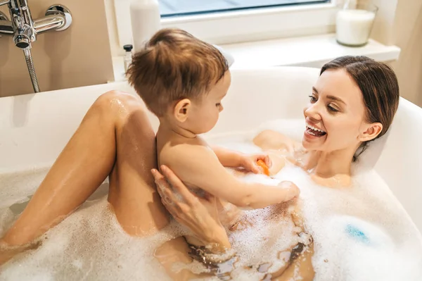 Η όμορφη κυρία κάνει μπάνιο με το παιδί της. — Φωτογραφία Αρχείου