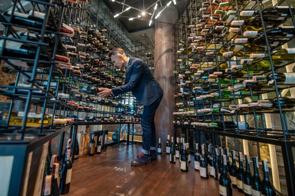 Şarap dükkanında şarap seçen bir erkek müşteri. — Stok fotoğraf