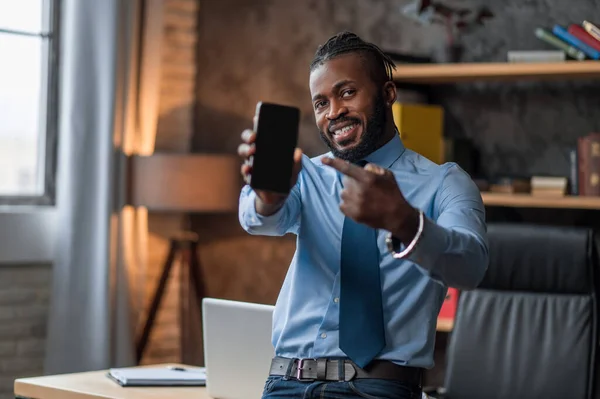 彼の携帯電話を見せる喜びのエレガントなビジネスマン — ストック写真