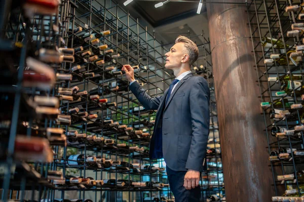 Een mannelijke klant die wina kiest in een wijnwinkel — Stockfoto