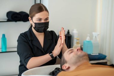 Erkek müşteriye masaj yapan güzellik uzmanı.