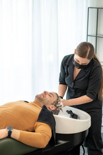 Jeune homme assis à l'appât tout en ayant massage de la tête et l'air détendu — Photo