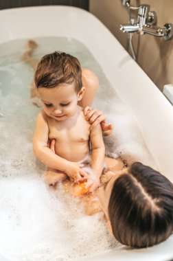 Anne çocuğuyla banyo yapıyor.