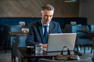 Orta yaşlı bir iş adamı dizüstü bilgisayarda oturup şöyle düşünür: