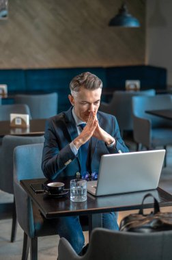 Orta yaşlı bir iş adamı dizüstü bilgisayarda oturup şöyle düşünür: