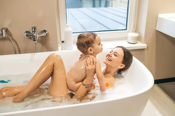 Liebevolle Mutter genießt das Baden mit ihrem Kind — Stockfoto