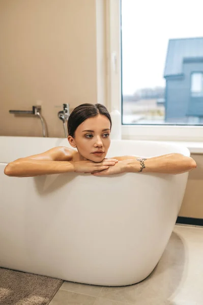 Задумчивая женщина, сидящая в ванной — стоковое фото