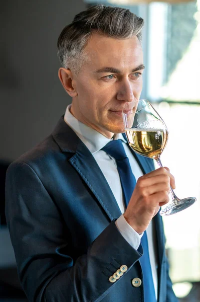 Hombre sonriente con una copa de vino en las manos — Foto de Stock