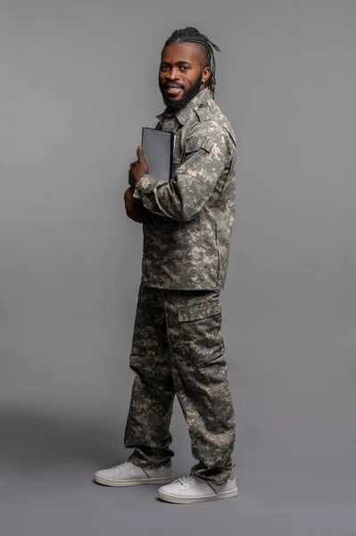 Joven soldado presionando documentos en su pecho — Foto de Stock