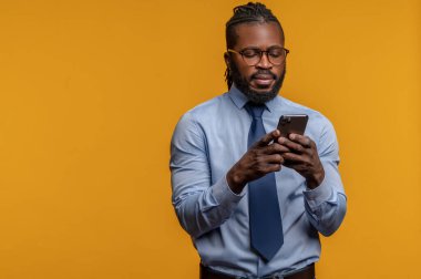 Akıllı telefonuna bakan konsantre genç girişimci.