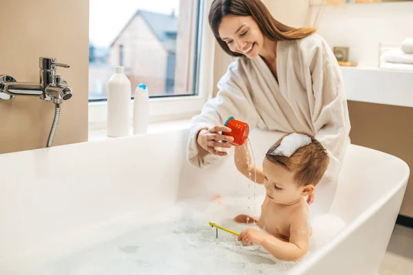 Lächelnde Mutter spielt mit ihrem entzückenden Baby — Stockfoto