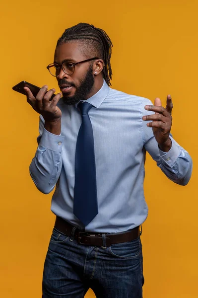 Joven empresario en gafas hablando en su smartphone — Foto de Stock