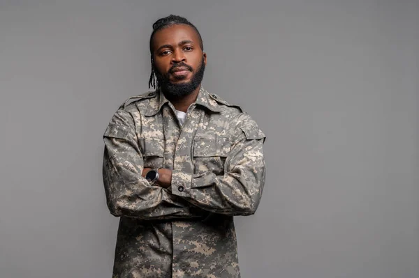 Tranquilo macho con uniforme caqui de pie junto a la pared — Foto de Stock