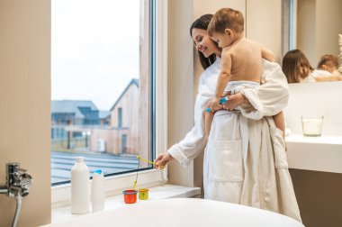 Neşeli genç anne çocuğuyla oynuyor.