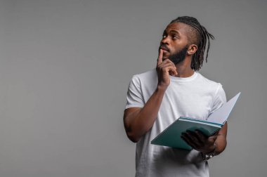 Afrikalı Amerikalı erkek öğrenci bir şey üzerinde kafa yoruyor.