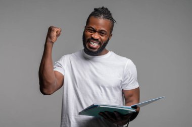 Başarılı olduğu için sevinen sevimli erkek öğrenci.