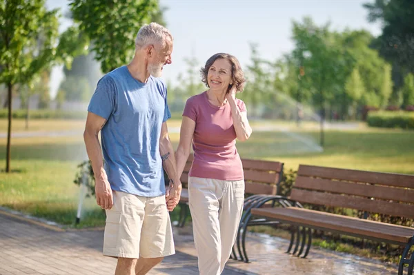 Una pareja de mediana edad dando un paseo por el parque — Foto de Stock