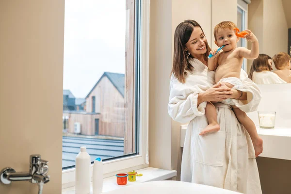 Fröhliche weibliche Eltern und ihr kleiner Junge im Badezimmer — Stockfoto