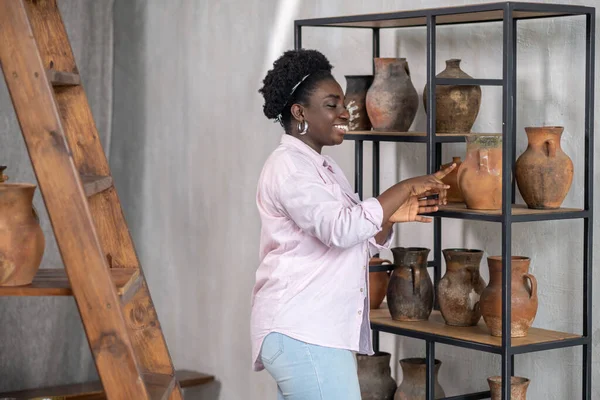 在陶瓷工作室里微笑着穿着粉色衣服的非洲女人 — 图库照片