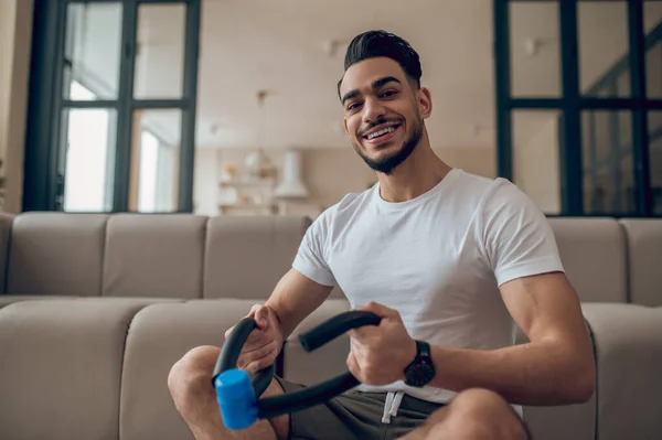 Young man exercising at home with expander — ストック写真