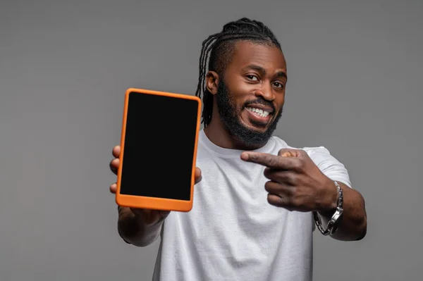 Feliz chico afroamericano demostrando su gadget — Foto de Stock