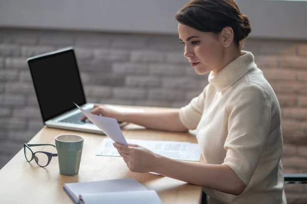 Een vrouw zit aan tafel in het kantoor en werkt. — Stockfoto