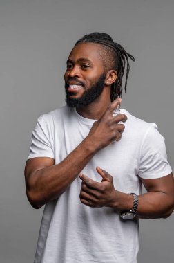 Kolonya sıkan mutlu genç bir adam.