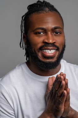 Gülümseyen, mutlu bir adam. Beklentilerini elle ovma hareketiyle gösteriyor.