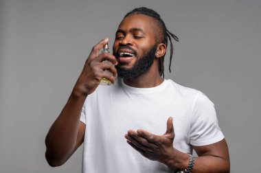 Gözleri kapalı, parfüm sıkmış bir erkek.