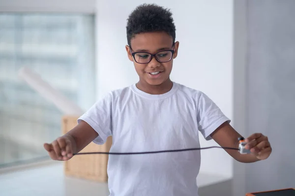 En midja upp bild av en pojke med en usb kabel i händerna — Stockfoto