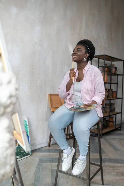 Nöjd afrikansk konstnär i rosa kläder ser inspirerad — Stockfoto