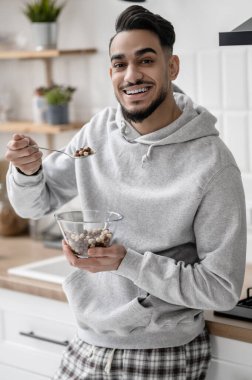 Genç bir adam sabahını evde kahve içerek geçiriyor.