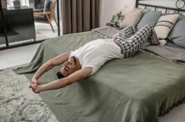 Yatakta uzanmış ve rahatlamış görünen bir adam.