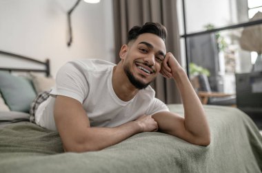 Genç bir adam bütün gününü evde geçiriyor ve kendini rahat hissediyor.