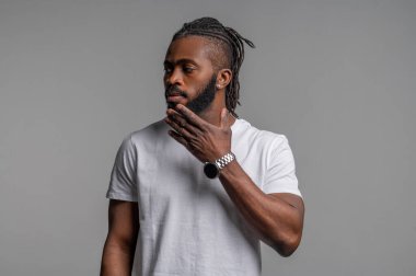 Rastalı düşünceli yakışıklı adam evde tek başına dikiliyor.