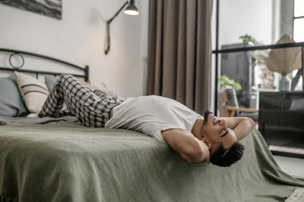 Un hombre acostado en la cama abnd buscando relajado — Foto de Stock