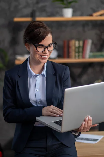 Elegant dark-haired woman with a laptop in hands — ストック写真