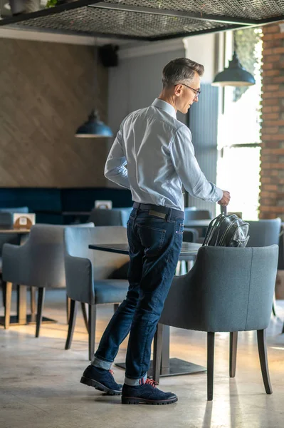 Kafede bir yer seçen yakışıklı bir adam.