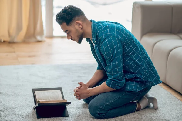 Young muslim praying at home and reading Quran — Stock Photo, Image