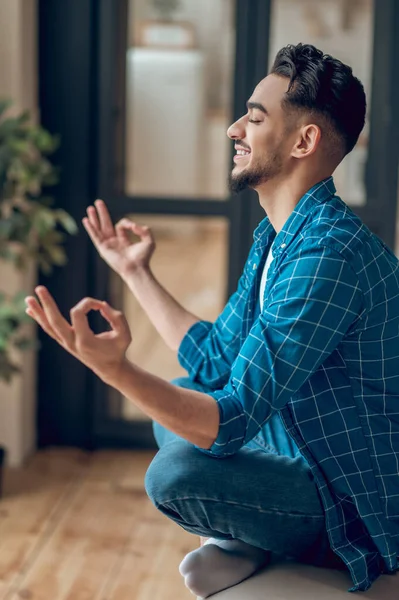 Positive young yogi sitting in lotus pose with fingers in giana mudra — Stock Photo, Image