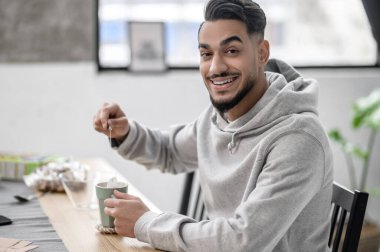 Sabahı evde geçiren ve çay hazırlayan bir adam.