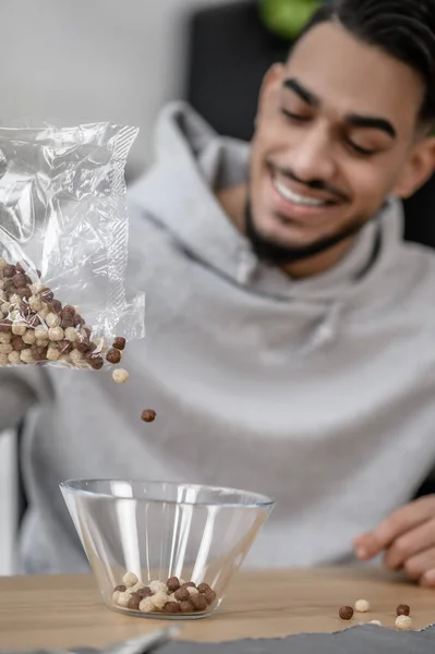 A smiling man in a grey hoodie making breakfast — Foto de Stock